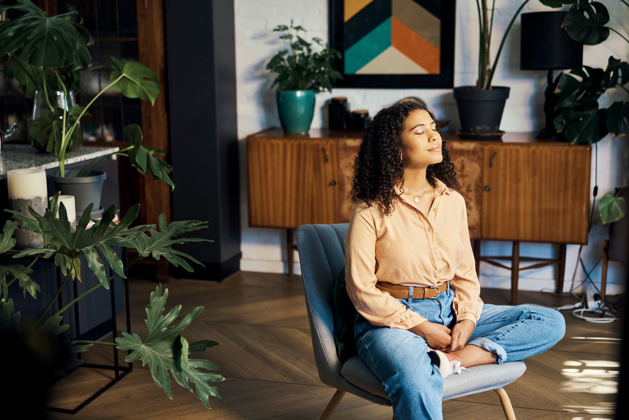 woman enjoying sunlight in room with plants while wondering ... what are the 8 dimensions of wellness?