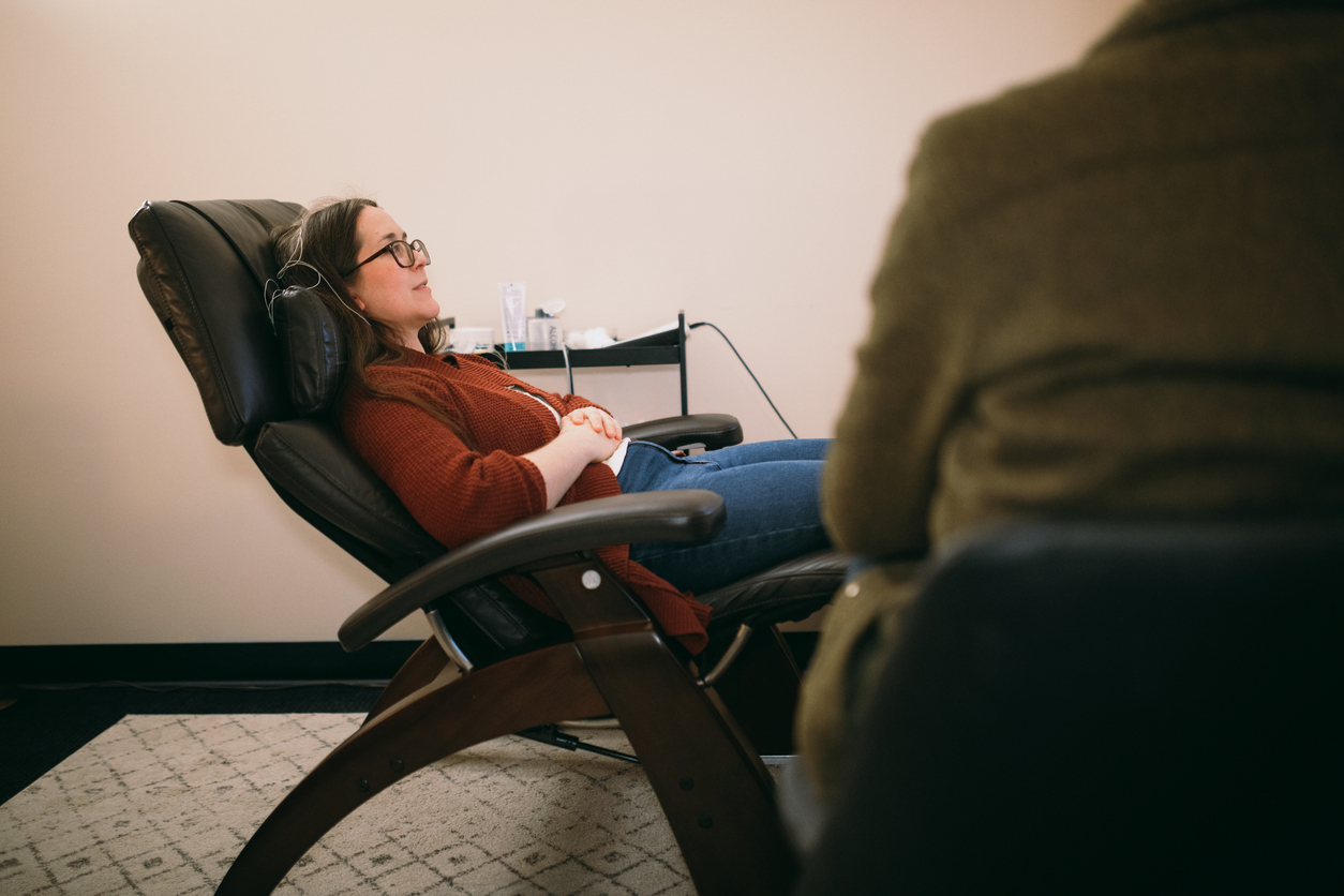 a woman relaxes in a chair during ketamine therapy session after exploring the question: what does ketamine therapy feel like?
